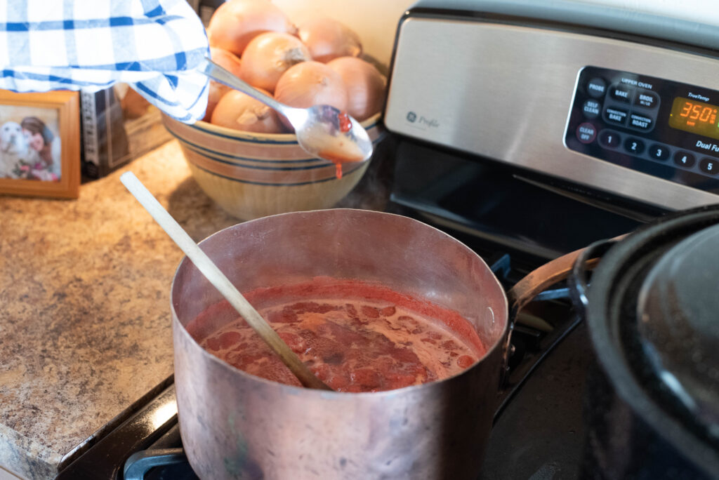 A frozen spoon testing the readiness of strawberry jam