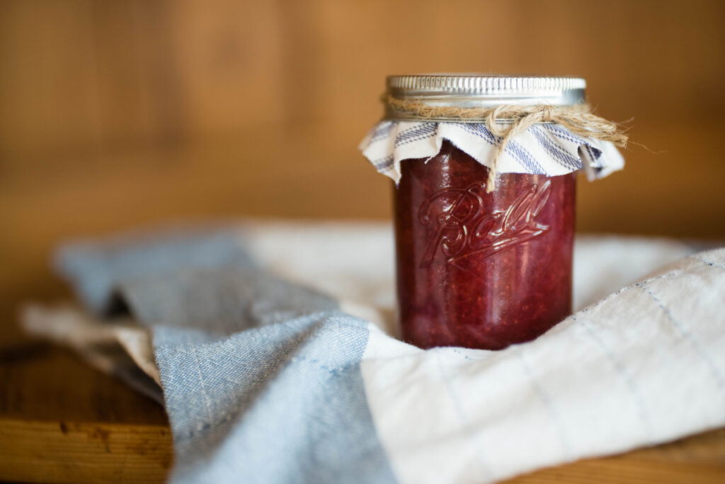 new gardener's guide featuring small jar of strawberry jam nestled on ticking stripe tea towel