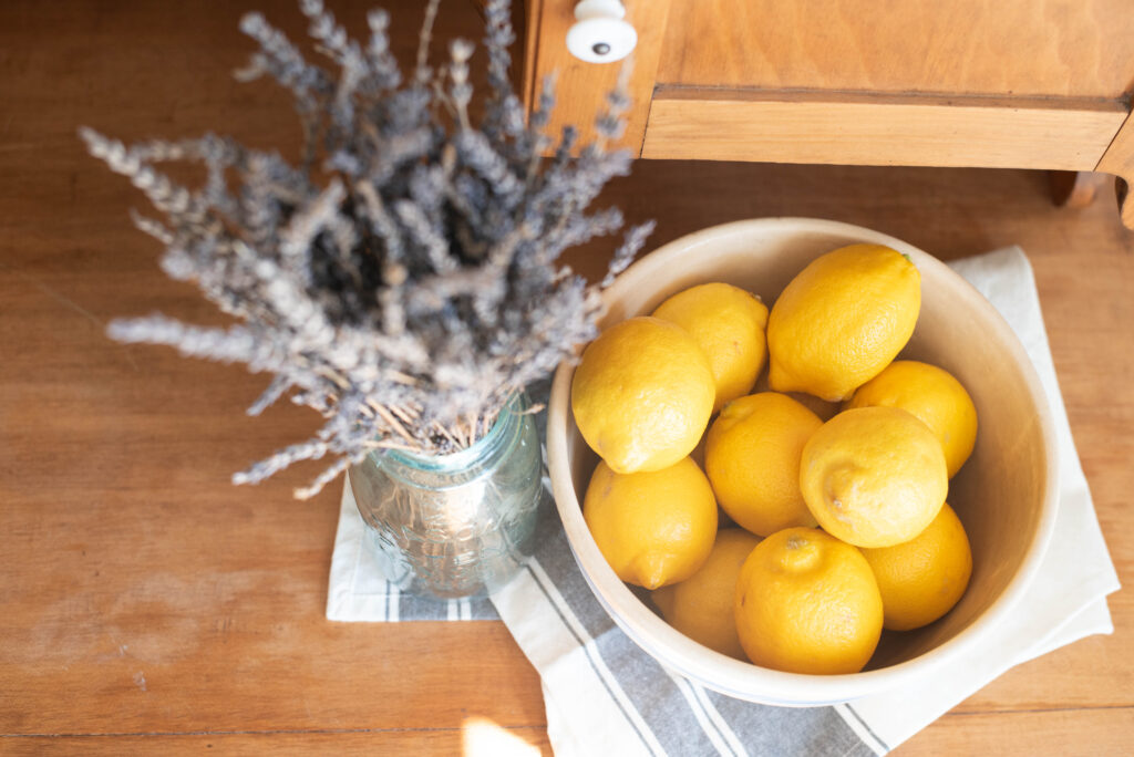 Bowl of lemons with a vase of dried lavender