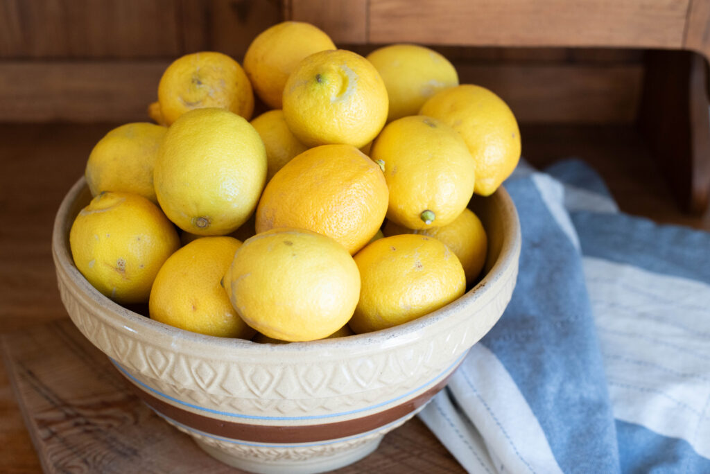 Bowl of lemons in antique stoneware on bakers hutch