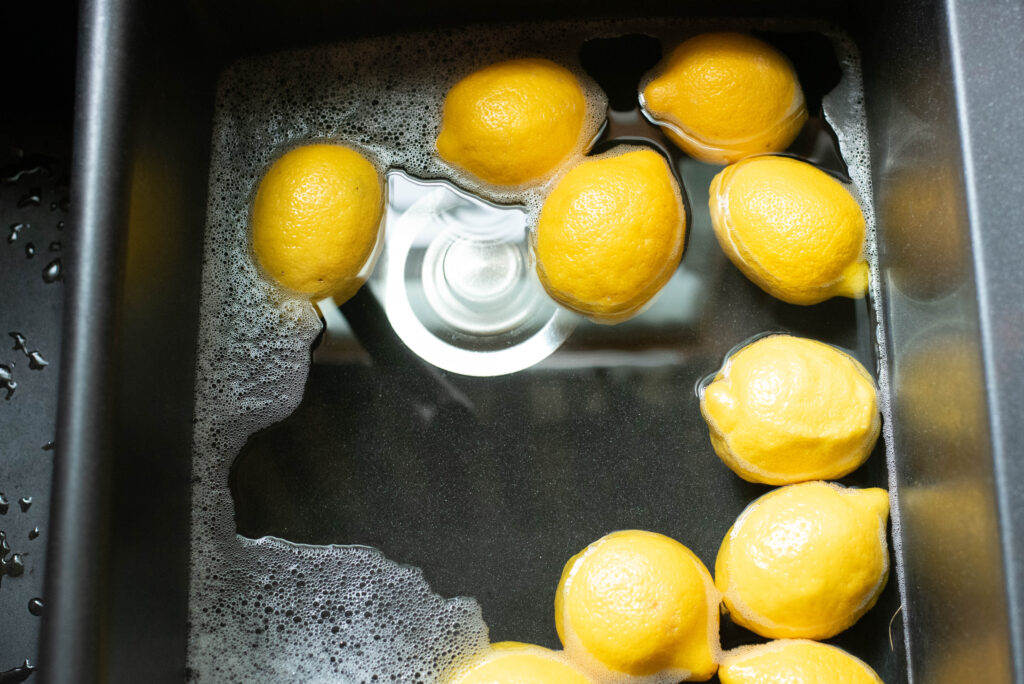 Lemons being washed in sink