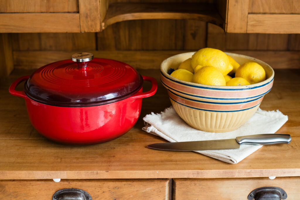 Red enamel cast iron, bowl of lemons and knife for cutting