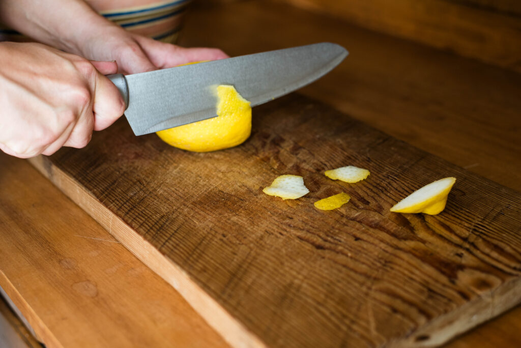 Lemon rind being cut away from pith