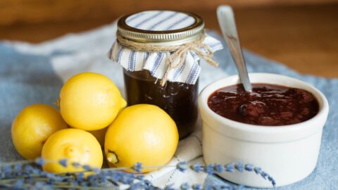 lemons, jar of homemade pectin and bowl of strawberry jam