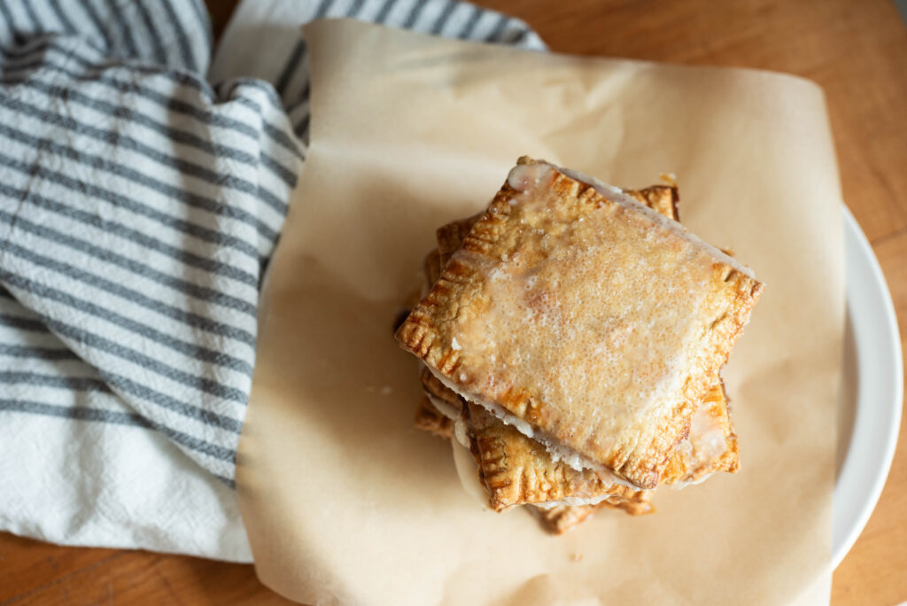 Pumpkin Hand Pies with Honey Cardamon Icing on plate with ticking stripe tea towel