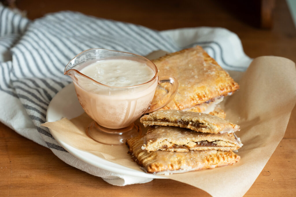 Easy from-scratch pumpkin hand pies with glass pitcher of icing