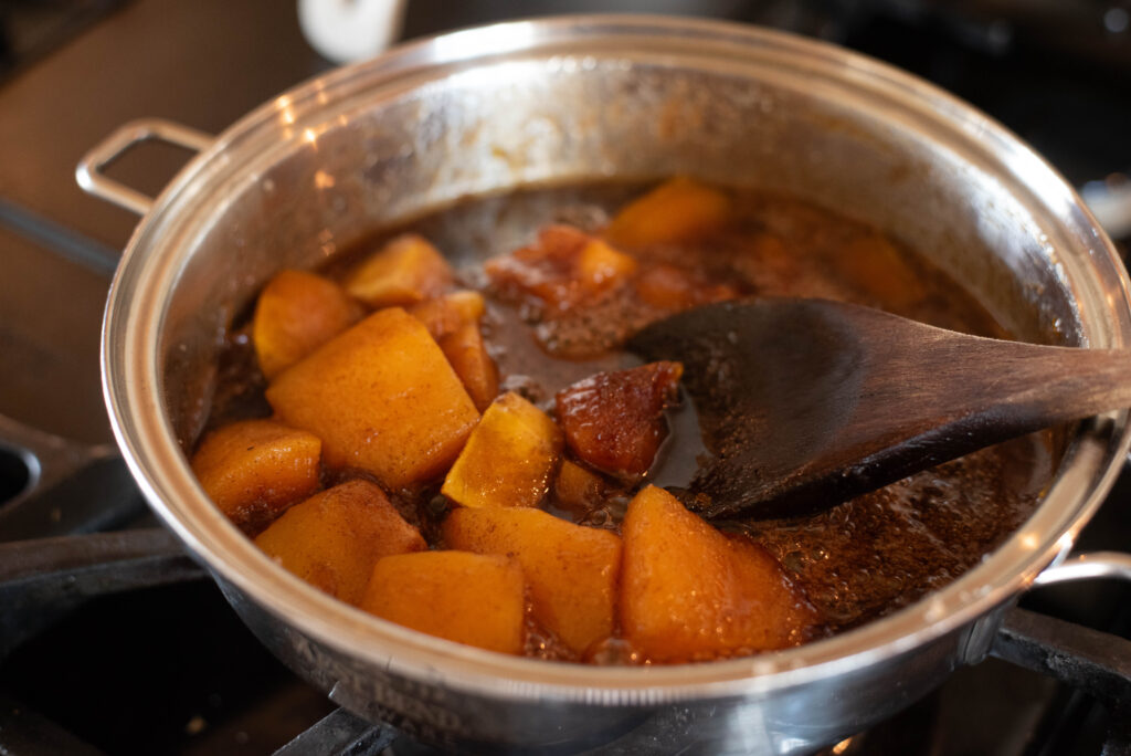 Pumpkin chunks with sugar and spices simmering on stovetop