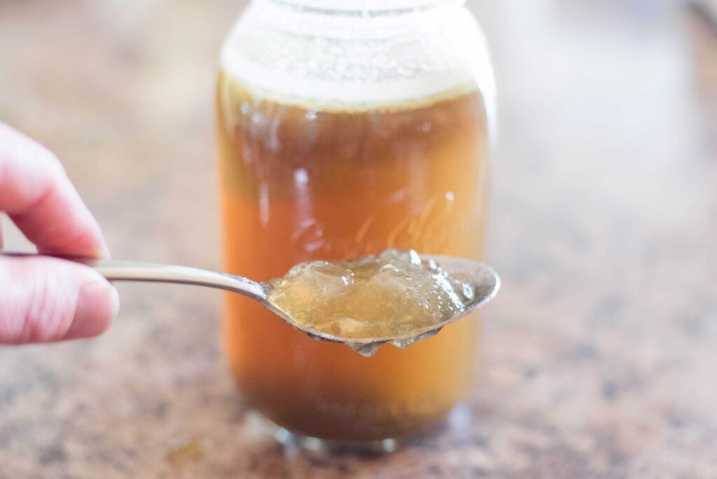 Gelatinous bone broth resting on a spoon