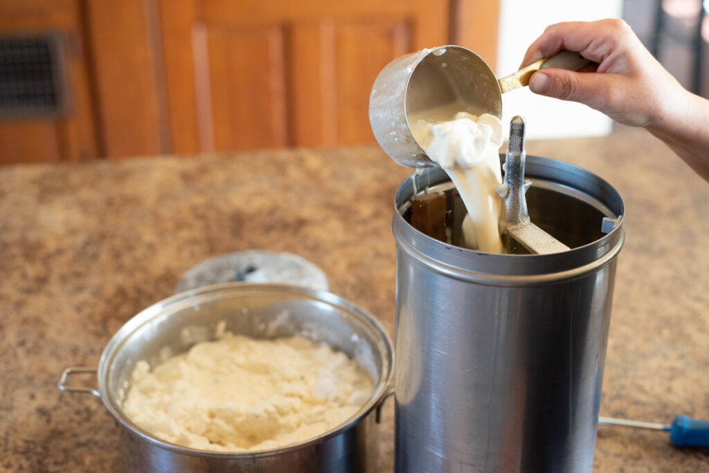 Hand pouring ice cream mixture into canister