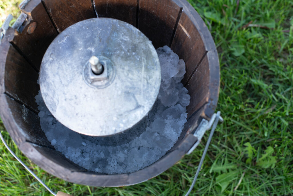 Layer of ice and rock salt in manual ice cream maker.