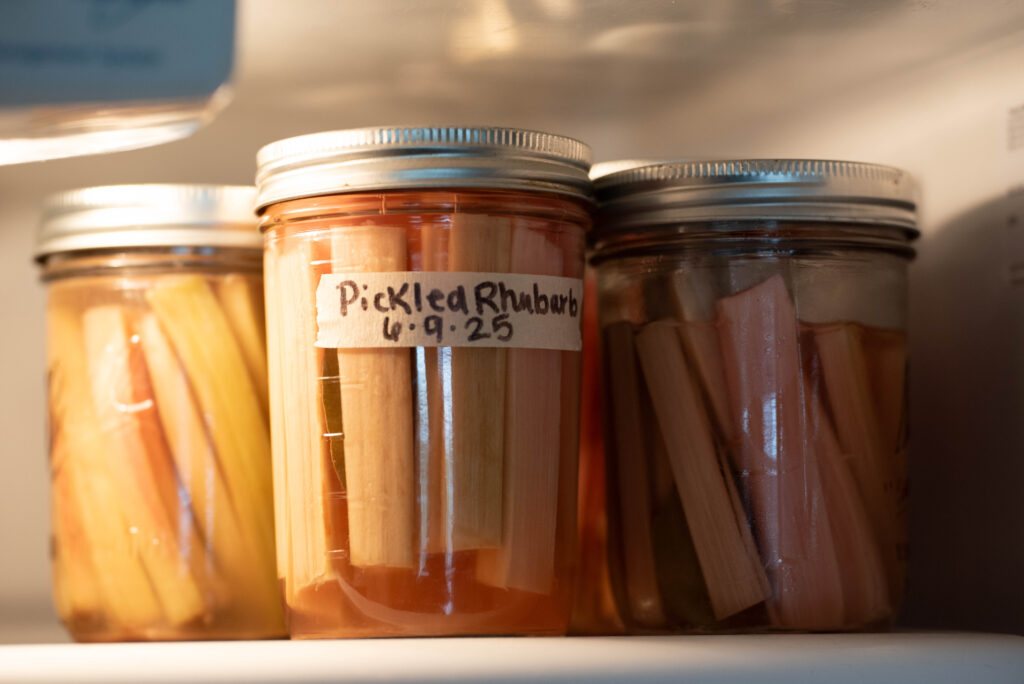 Jars of rhubarb being stored in the refrigerator.