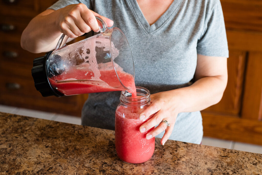 Watermelon puree being poured in jar.