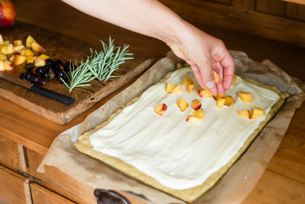 Hand assembling fruit on fruit pizza