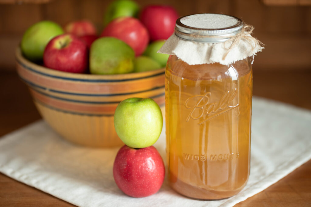 Fresh apples with jar of apple cider vinegar