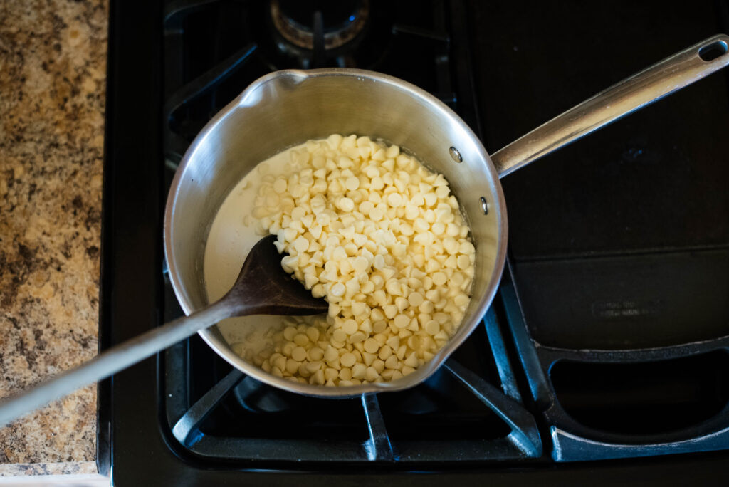 White chocolate chips and heavy cream being melted together for ganache