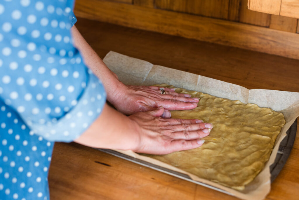 Cookie dough being spread on a cookie sheet.