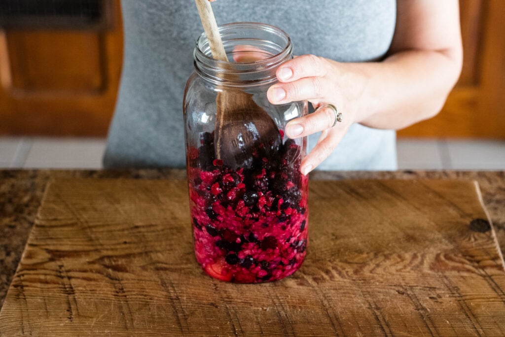 Jar of fruit mixed with honey and apple cider vinegar.