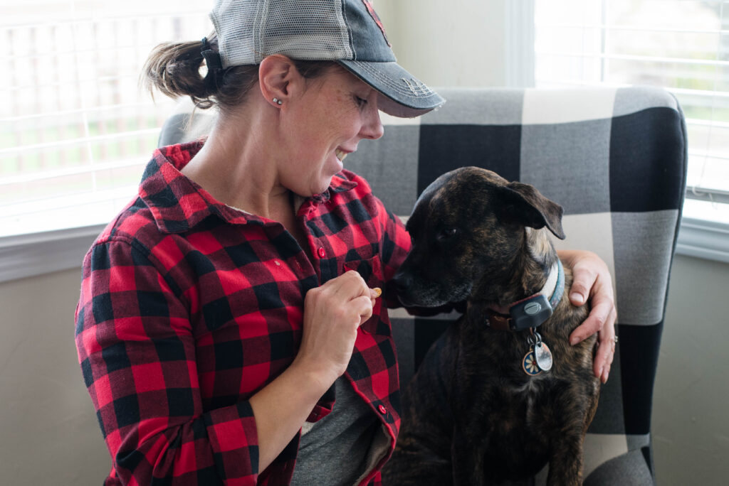 Woman giving dog a treat.