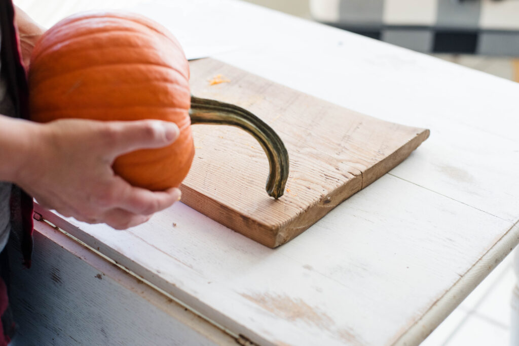 The stem being removed from a pumpkin.