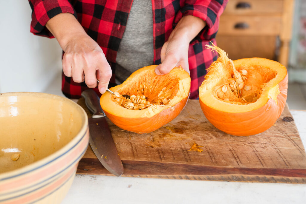 Pumpkin seeds being scooped out.