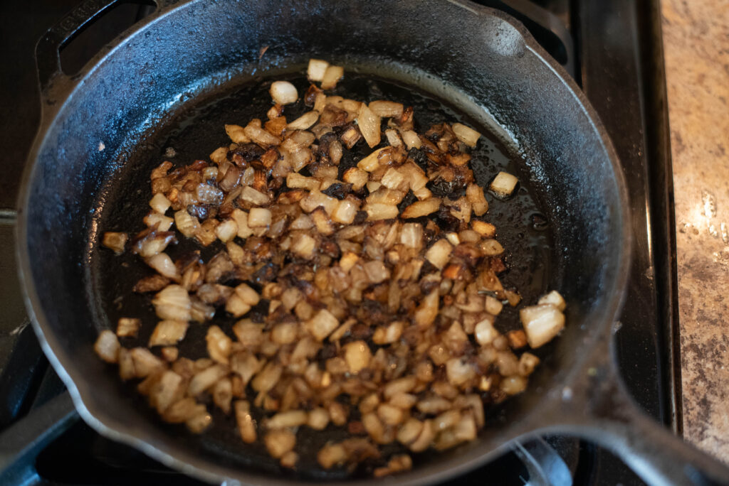 Onions cooking in a cast iron skillet