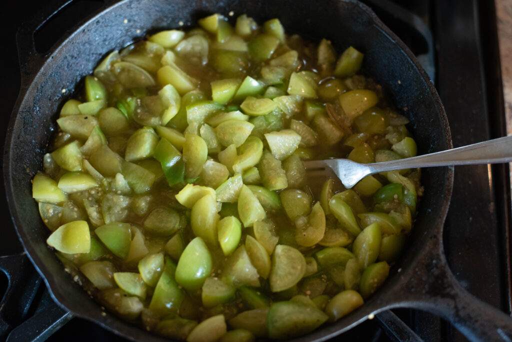 Tomatillos roasting in a cast iron skillet 