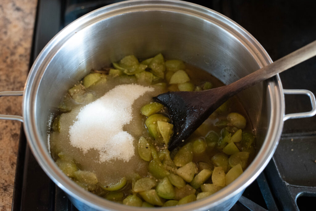 Tomatillo jam being cooked with sugar and onions.