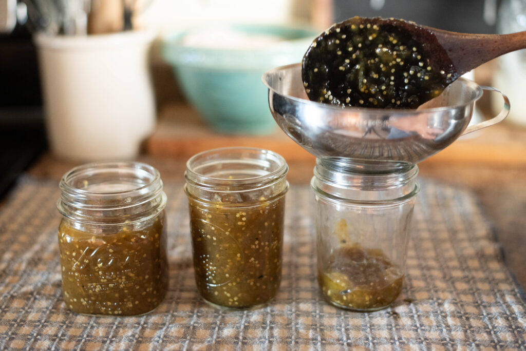 Jam being ladled into jars.