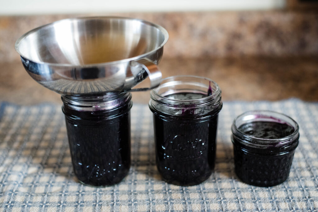 Jam being ladled into jars.