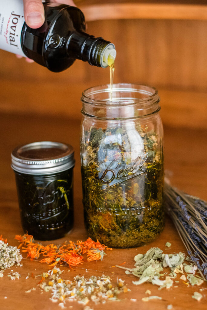 Olive oil being poured over herbs for an herb infused oil