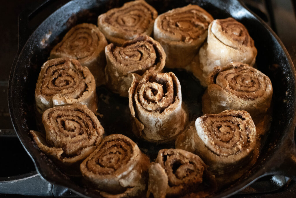 sourdough gingerbread cinnamon rolls before baking in a cast iron skillet