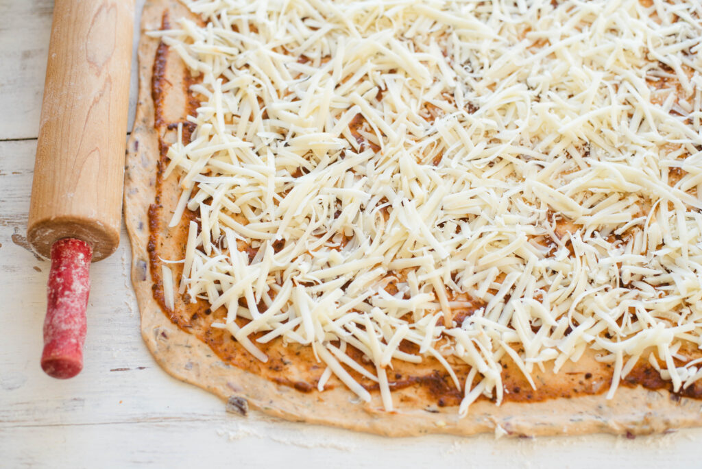 cheesy sourdough pizza rolls rolled out with toppings