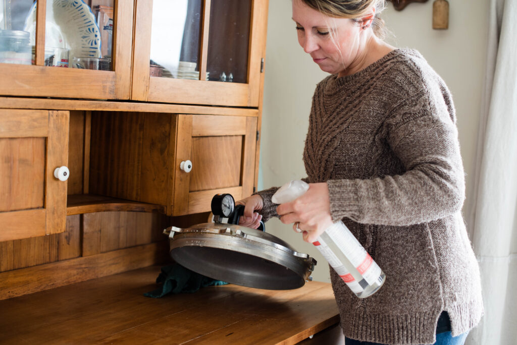 Woman cleaning lid before pressure canning.