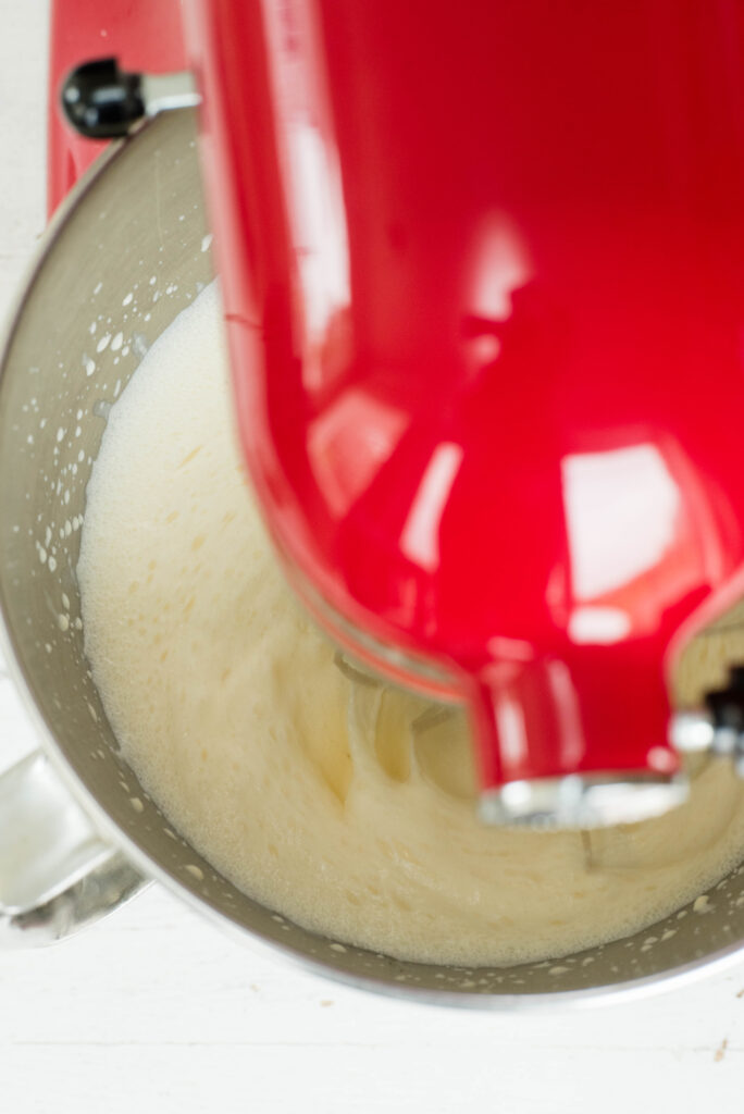 homemade whipped cream being whipped in a mixing bowl
