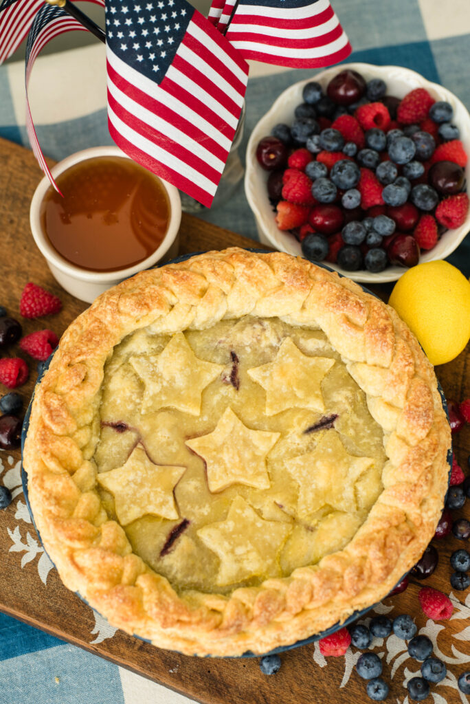 Mixed berry pie with honey decorated with star shapes and fresh fruit