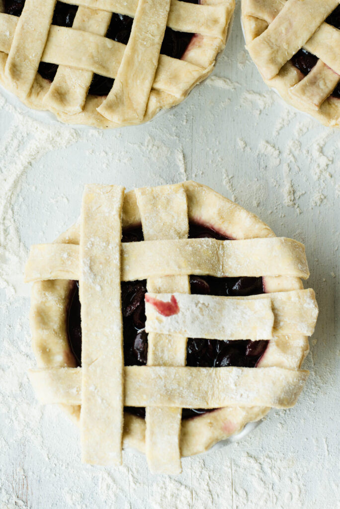 Cherry pie with middle strip of dough pulled back for a lattice top pie crust.