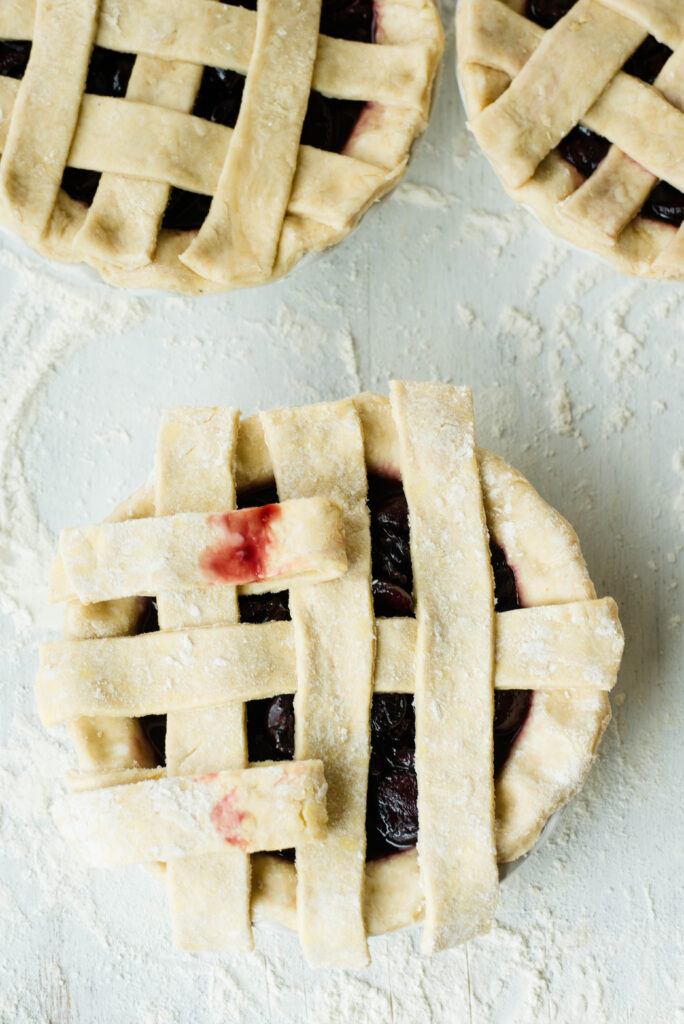 Top first and third strips of pie dough pulled back to make a lattice top crust.