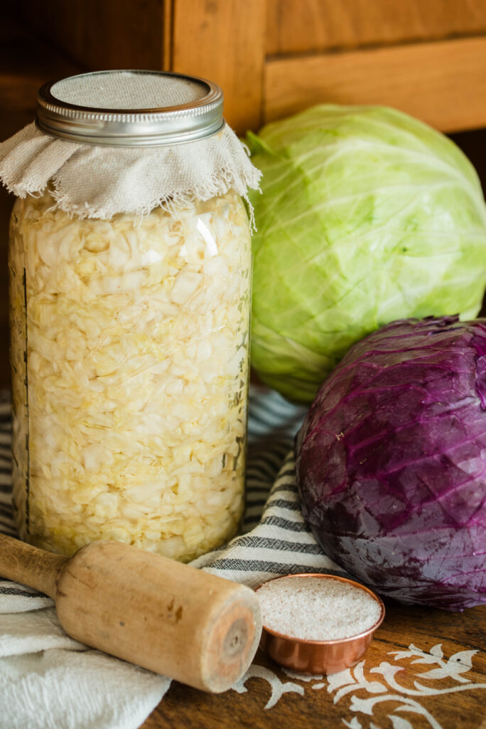 Jar of sauerkraut with fresh cabbage and salt.