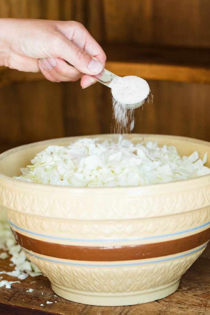 Salt sprinkled onto shredded cabbage for homemade sauerkraut.