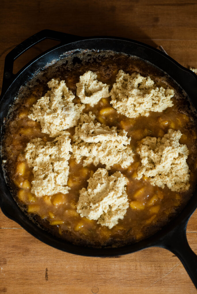 Peach cobbler in a skillet ready to be baked.