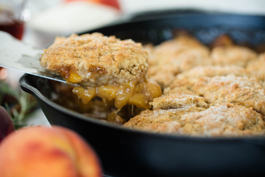 Side view of a scoop of old-fashioned peach cobbler from the skillet.