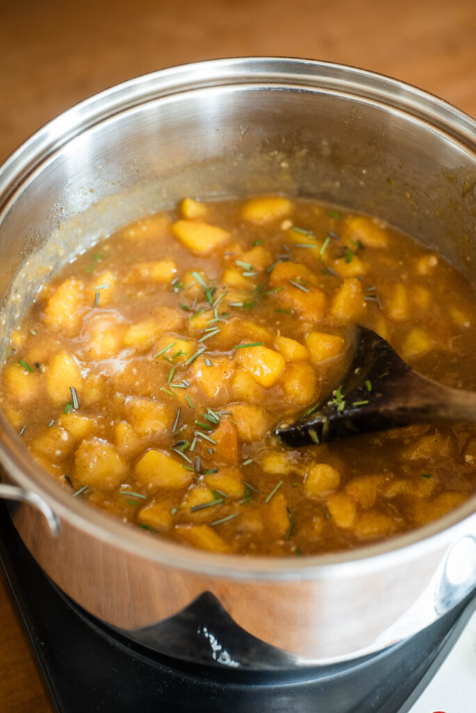 Lemon zest, rosemary and thickener being stirred into filling for old fashioned peach cobbler.