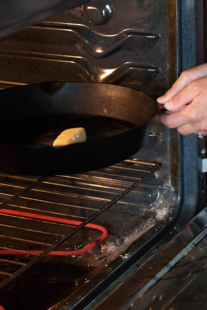 Cast iron skillet being put in the oven.