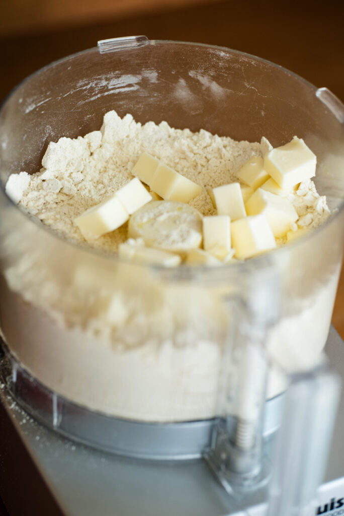 Cold diced butter added to dry ingredients for cobbler dough.