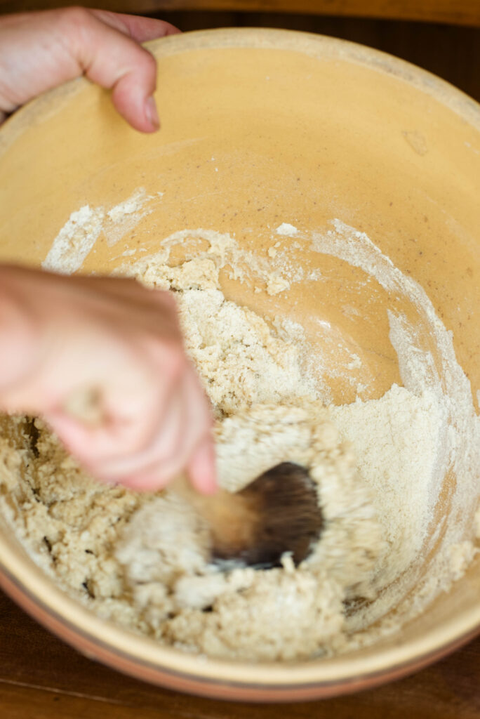Milk being stirred into dough for old fashioned peach cobbler.