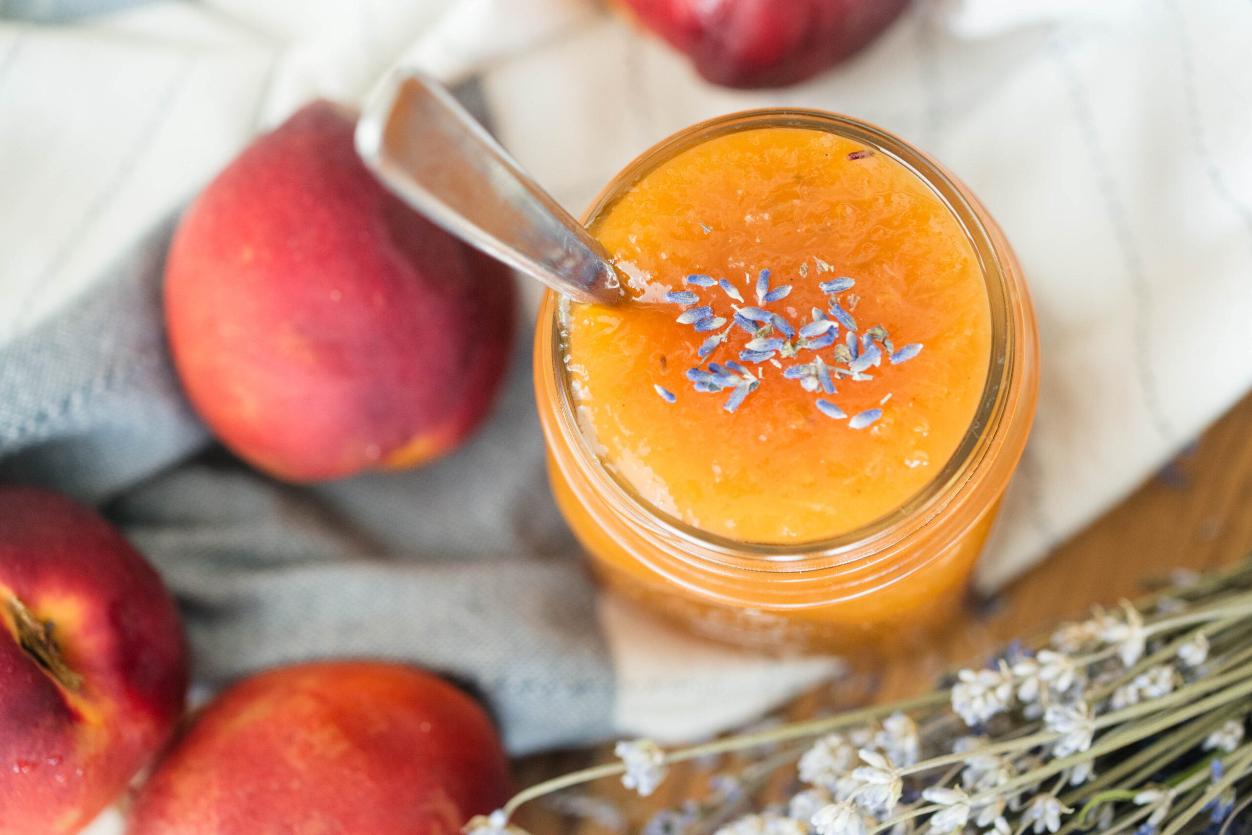 Peach lavender jam with fresh peaches and lavender buds.