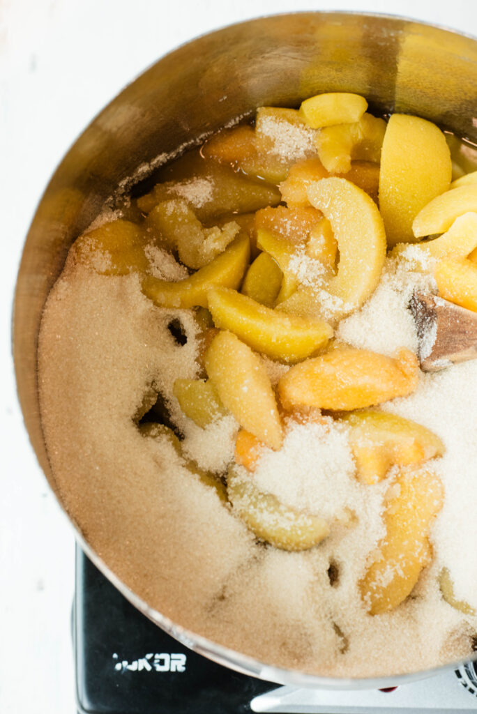 Sliced peaches with sugar for jam making.