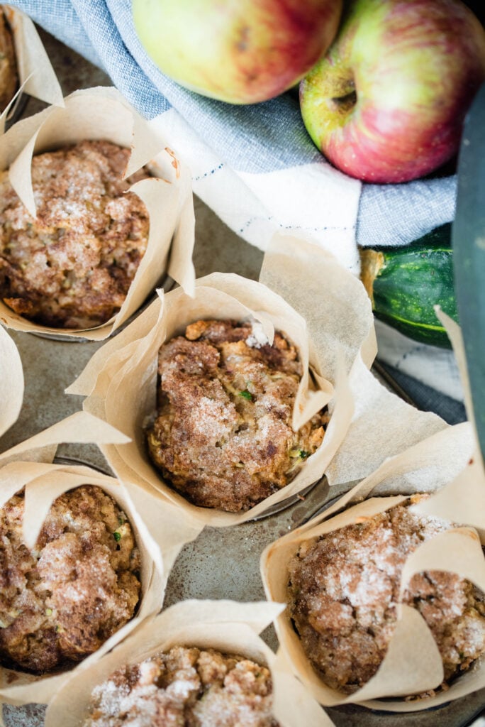 Apple spice muffins with zucchini baked and resting inside the muffin tray.