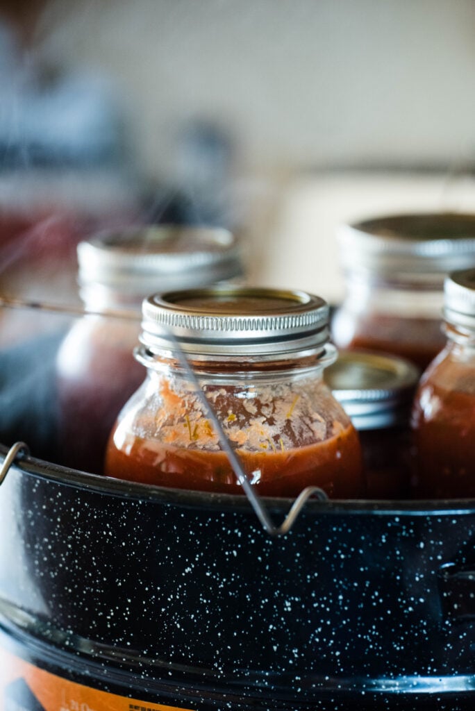 Jars of pasta sauce inside a water bath canner.