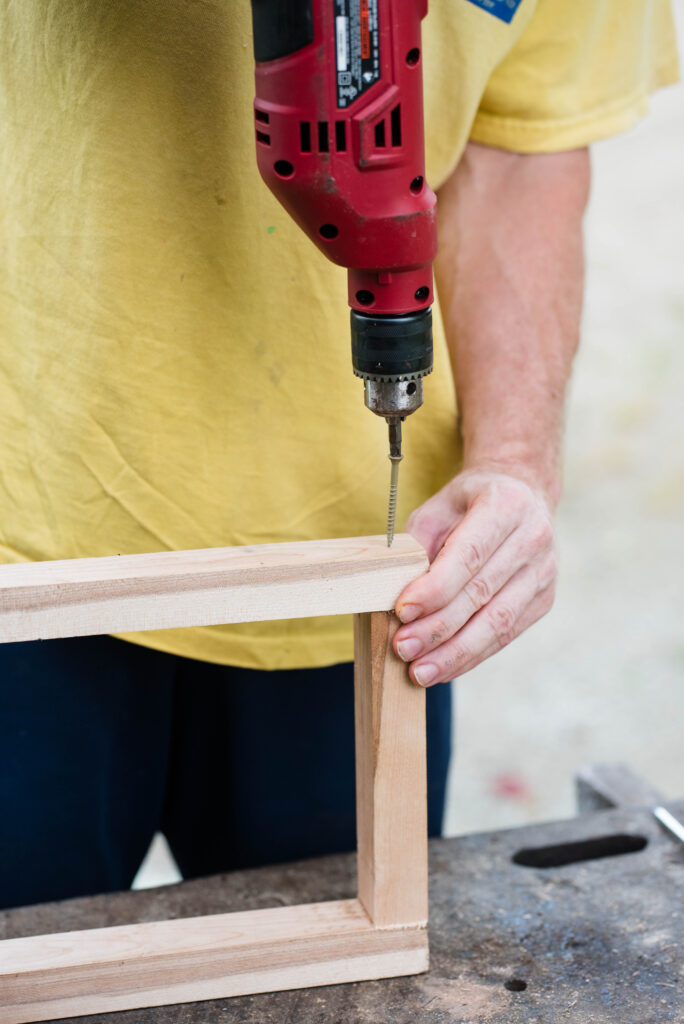 Screw being drilled into a board for a wood box.
